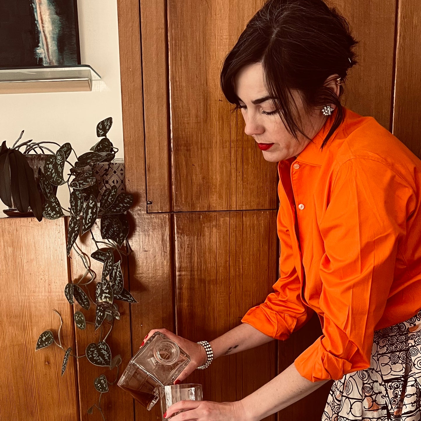 Person pouring decanter against wood background