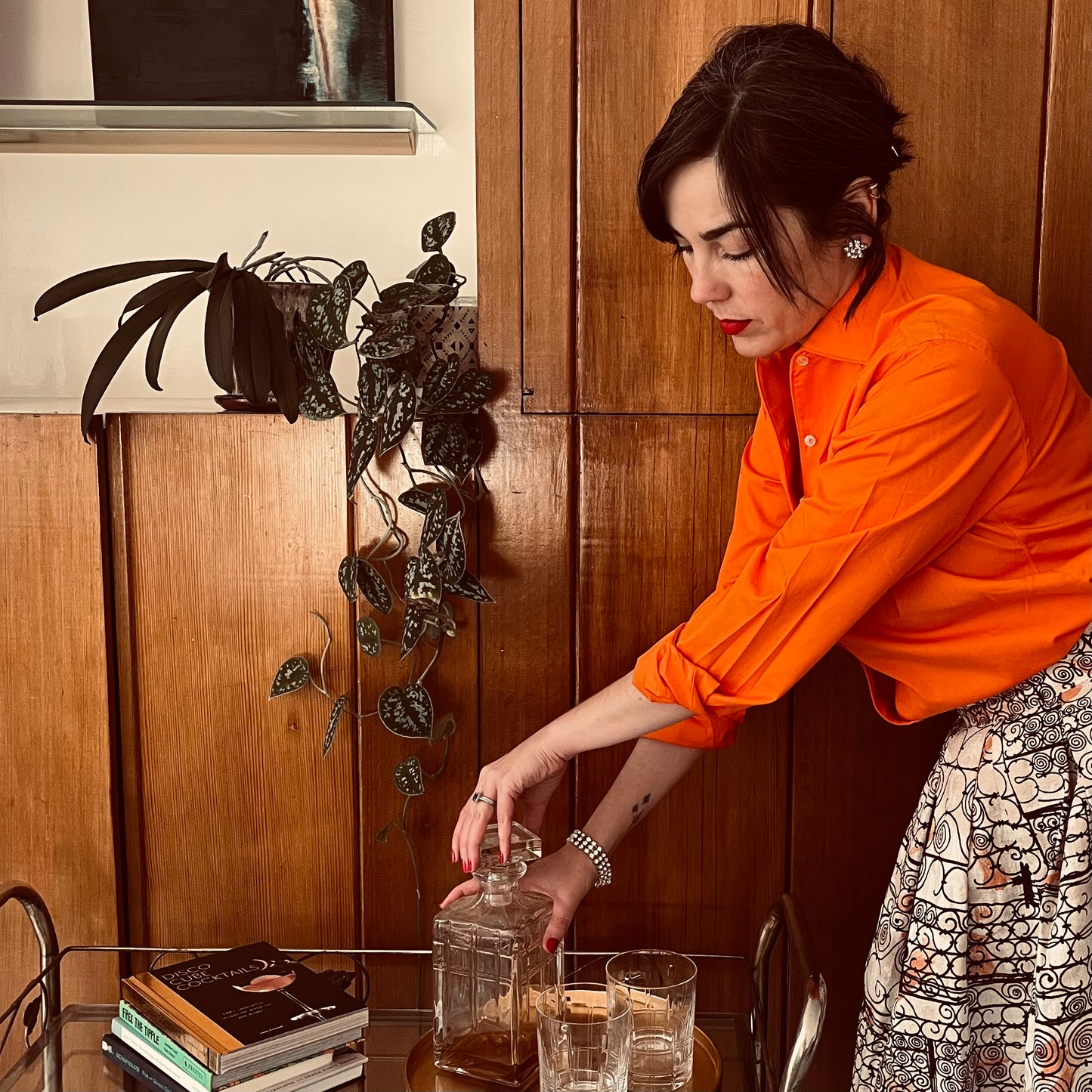 Person opening decanter against wood background