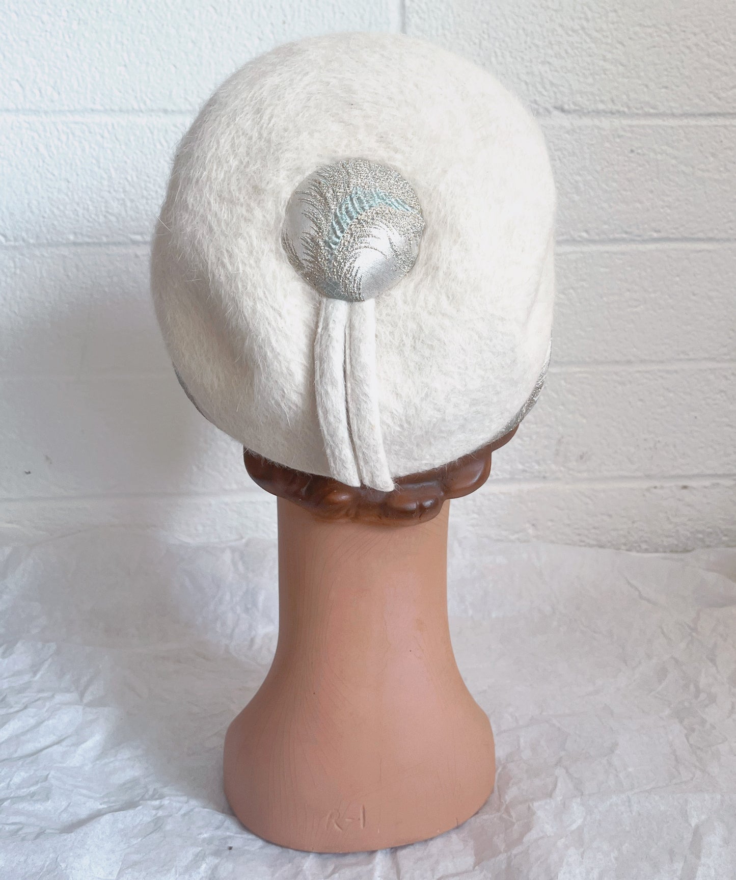 Back view image of hat on mannequin head. Shown against white brick background.
