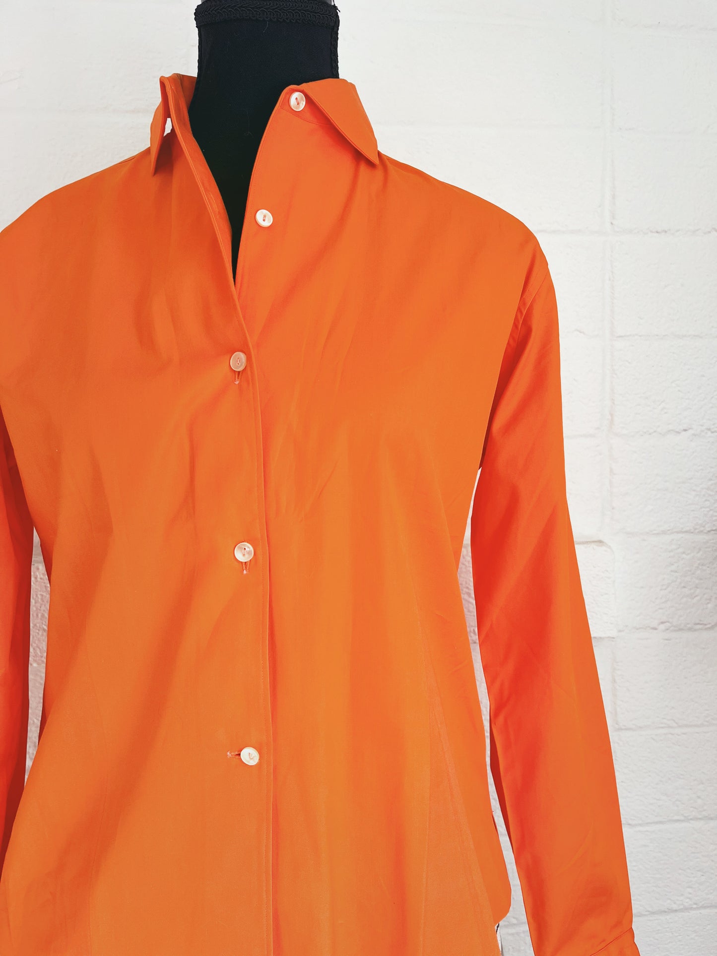 Close up of top on dress form with white background.