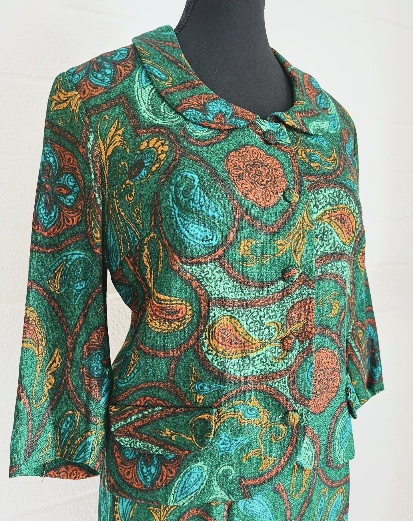 Close up angled image of suit jacket modelled on dressform. White background.