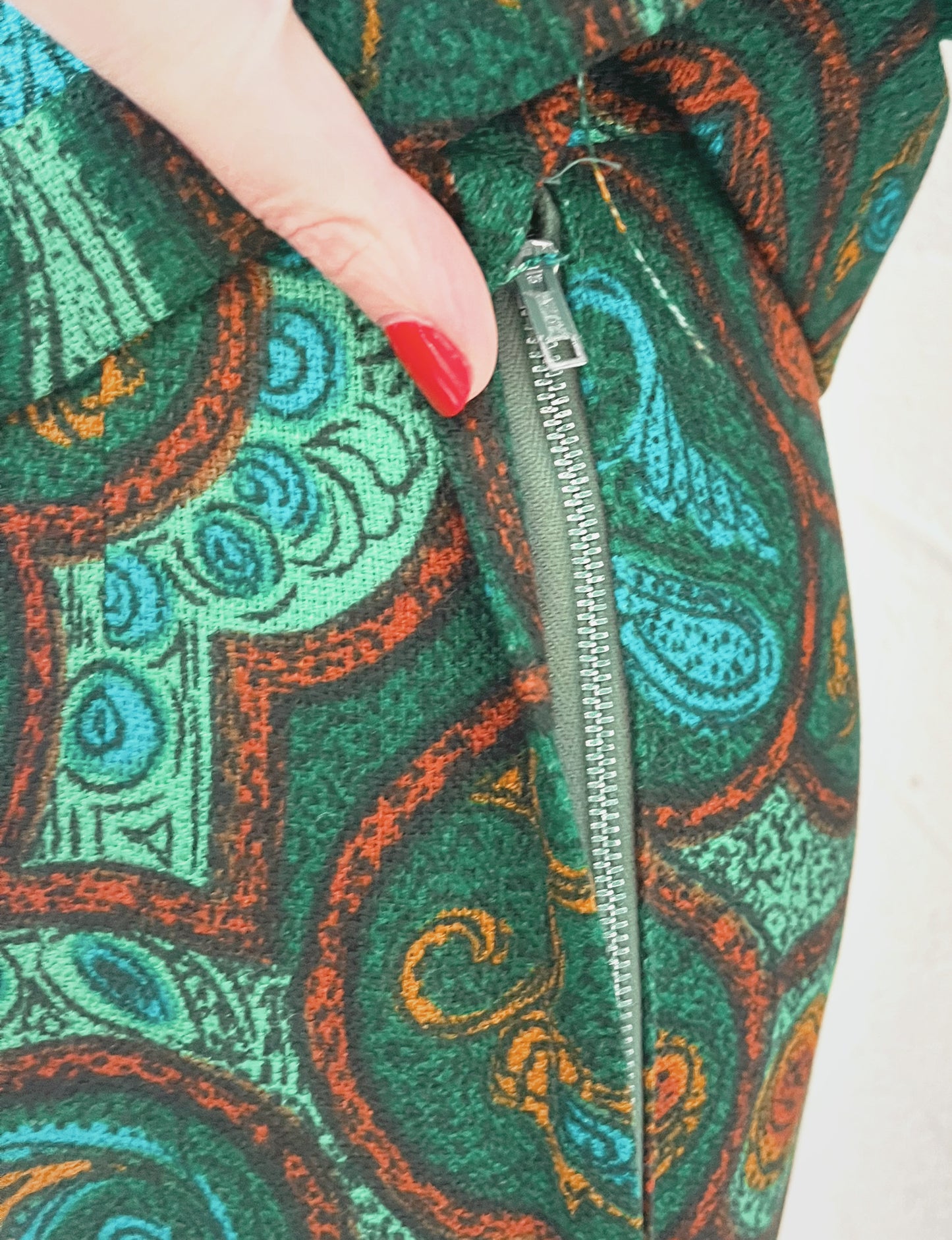 Close up of side zipper on skirt. White background.