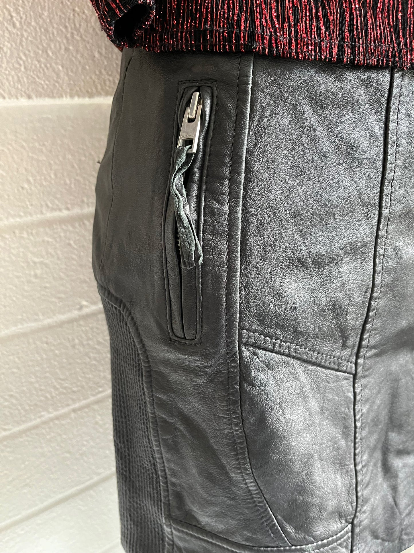 Close up of side zipper on skirt. White background.