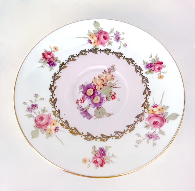 Close up of floral saucer.  White background.  