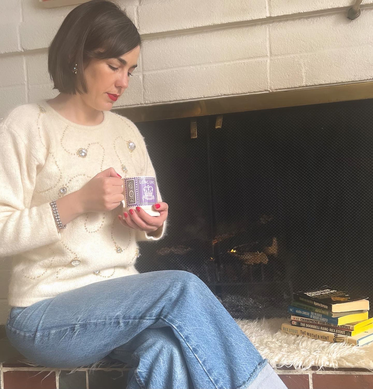 Image of person holding mug in front of fireplace 