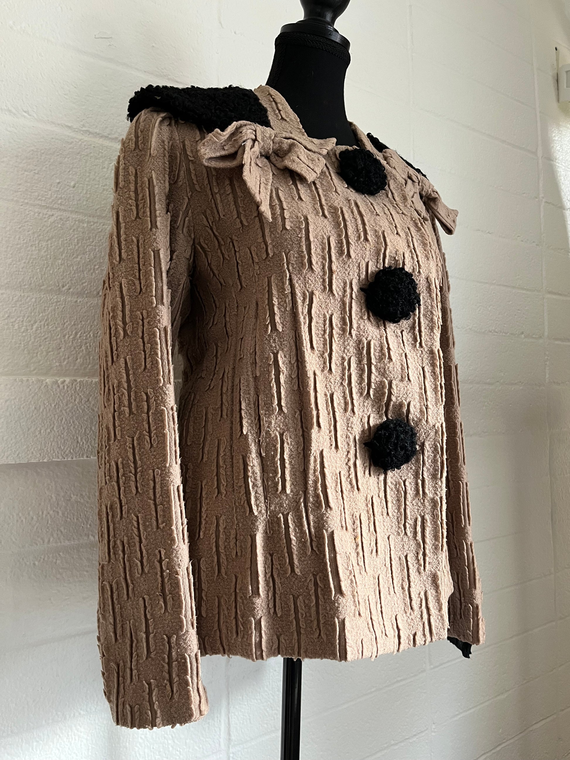 Angled image of jacket on dressform with white background.  