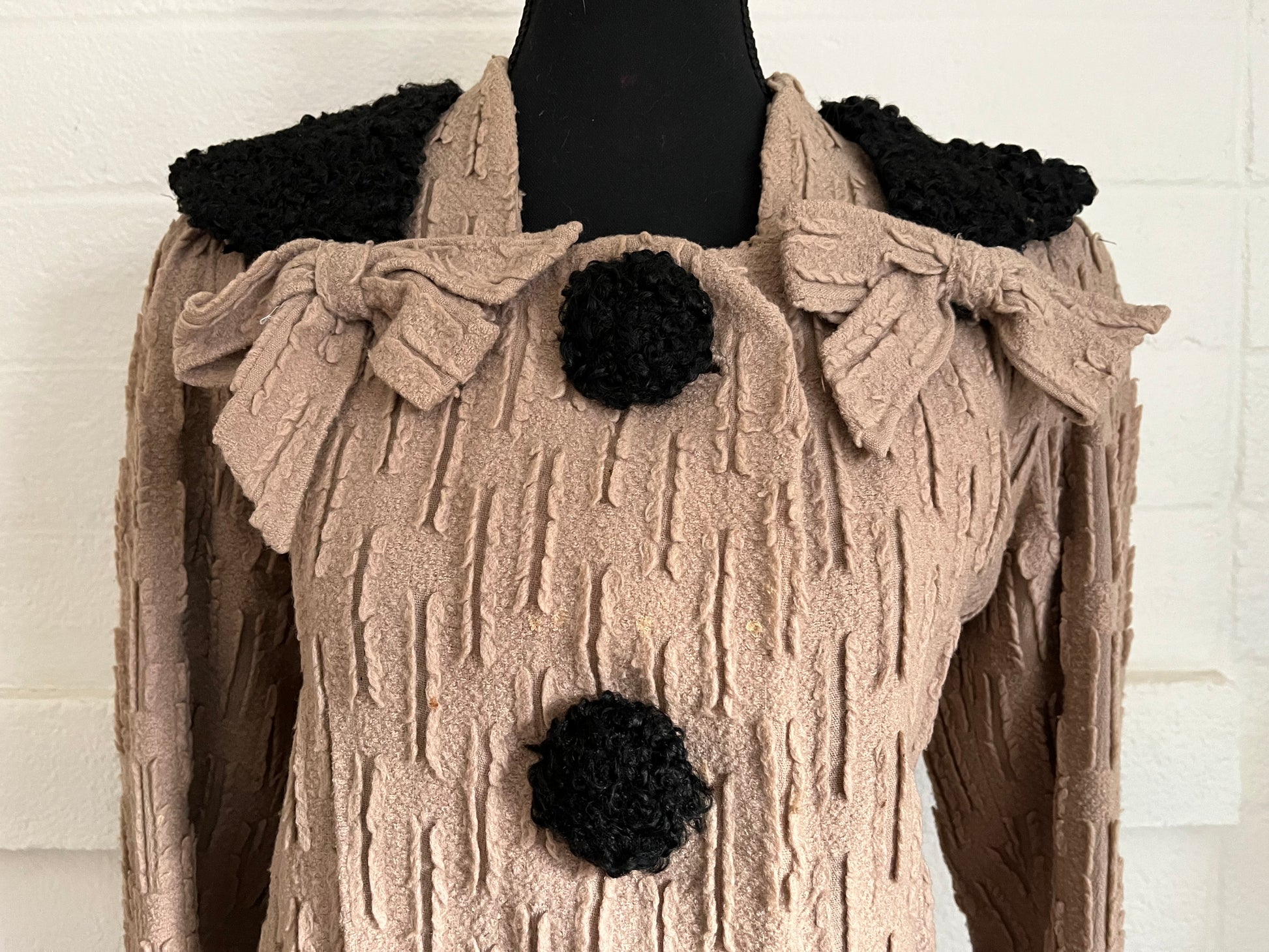 Close up image of jacket on dressform with white background.  