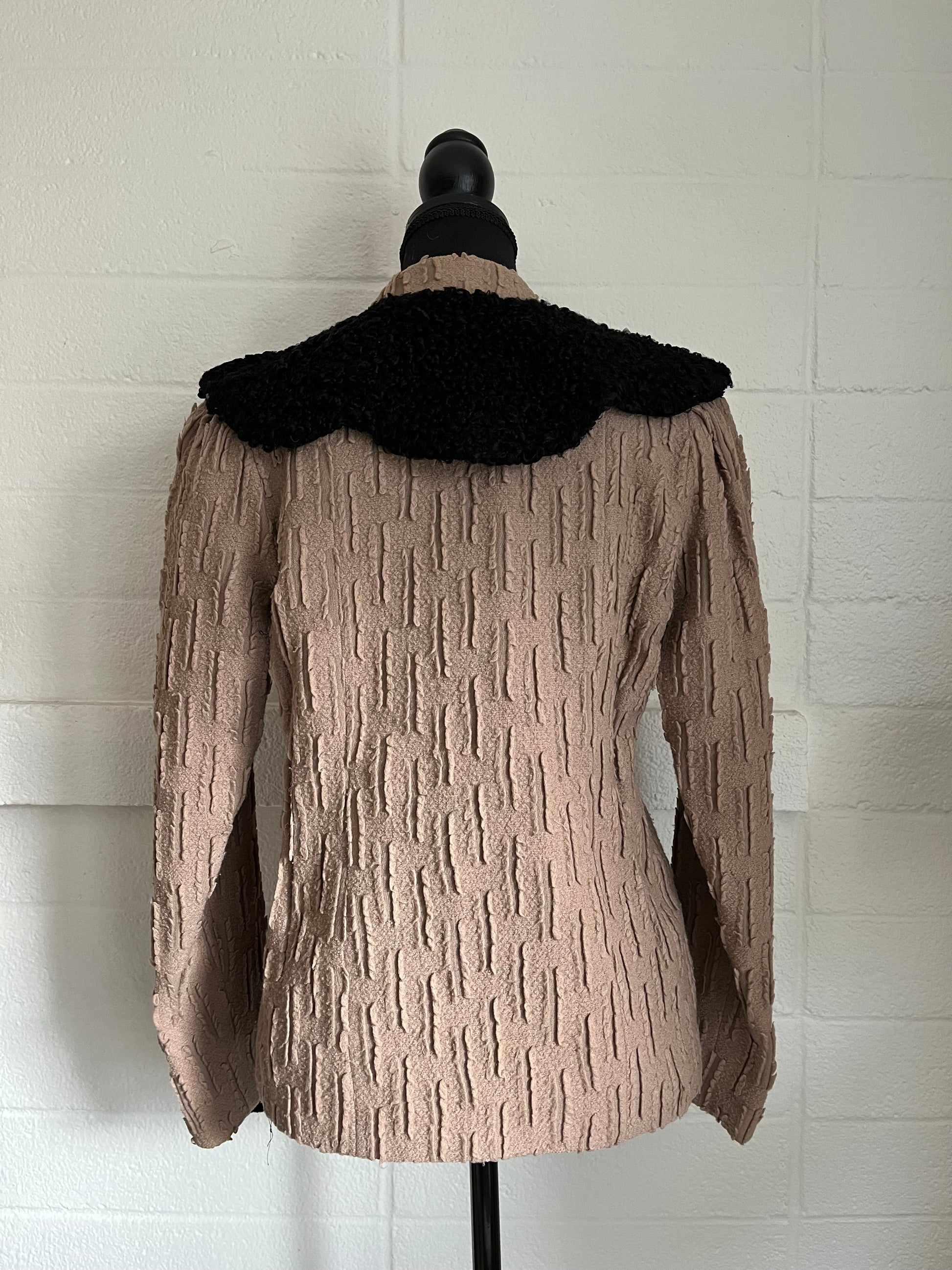 Backside image of jacket on dressform with white background.  