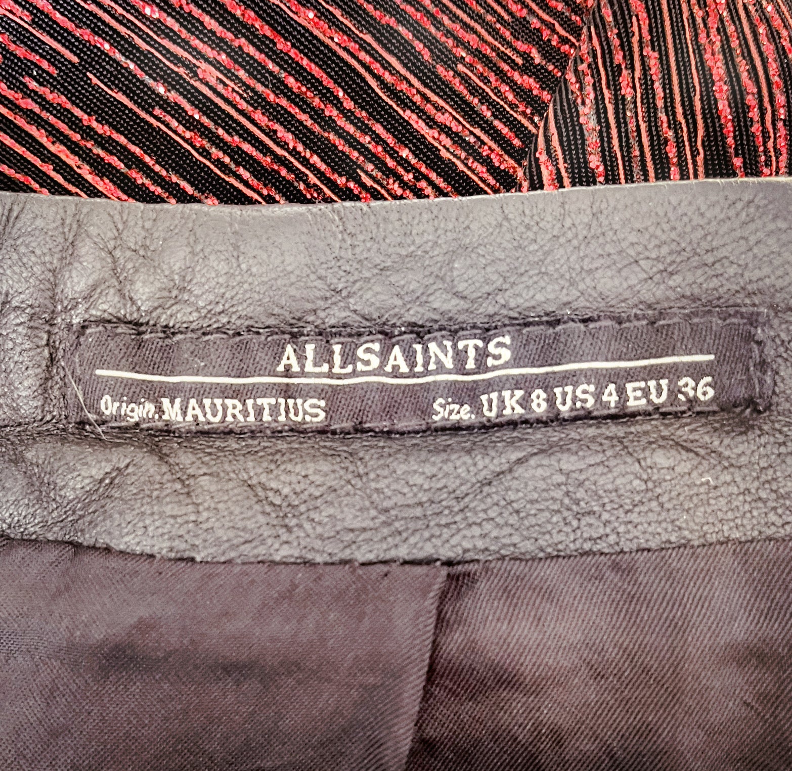 Close up of tag which reads "All Saints.  Origin Mauritius.  Size UK 8 US 4 EU 36."